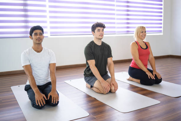 istock Serious beginners sitting in seiza pose on mats at yoga class 1018739722