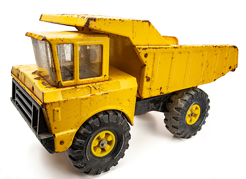 Rusted yellow toy truck isolated against white background