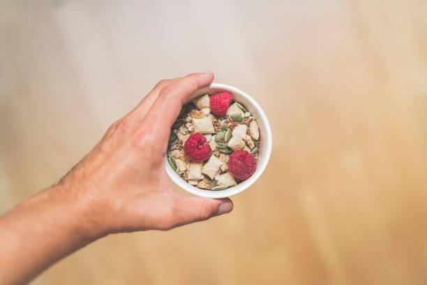istock Man holding a bowl of musli with raspberries 1018757344