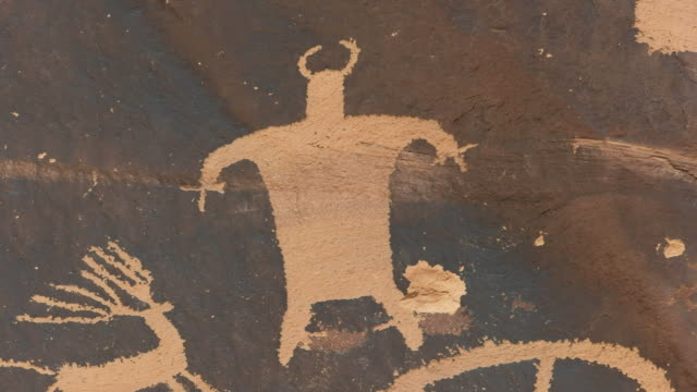 close up of a strange human like figure on newspaper rock in utah