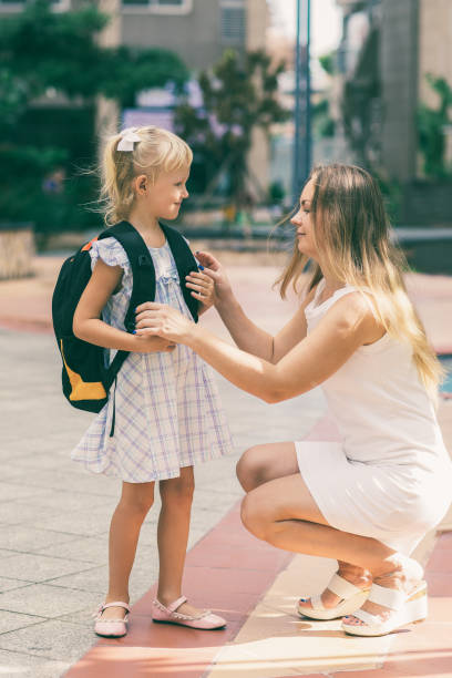 istock Mother Adjusting Daughter Clothes Before School 1018787880