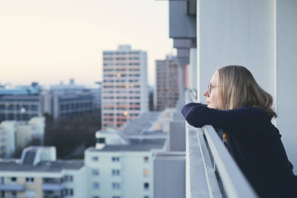 istock Woman on balcony at sunset 1018791698