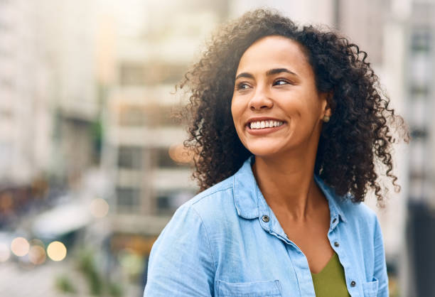 I'm just out living life Shot of an attractive young woman out and about in the city looking away stock pictures, royalty-free photos & images