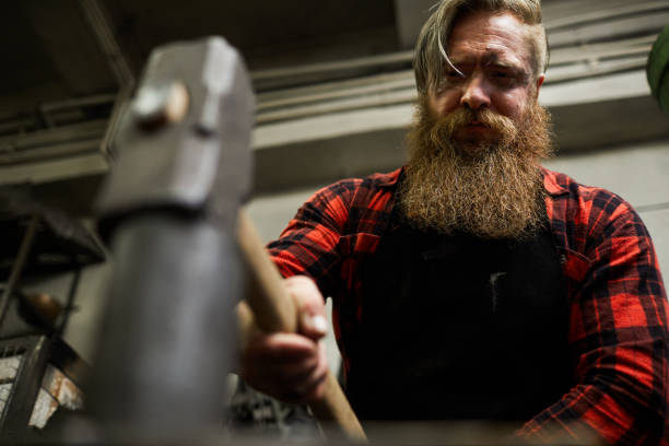 istock Strong blacksmith hammering metal detail 1018801186
