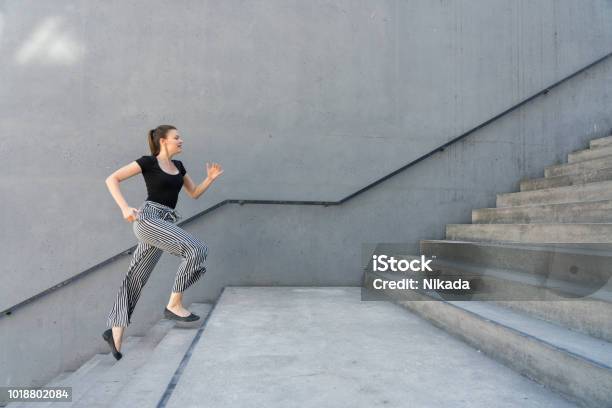 Woman Running Up Steps In Urban Setting Stock Photo - Download Image Now - Staircase, Steps, Moving Up