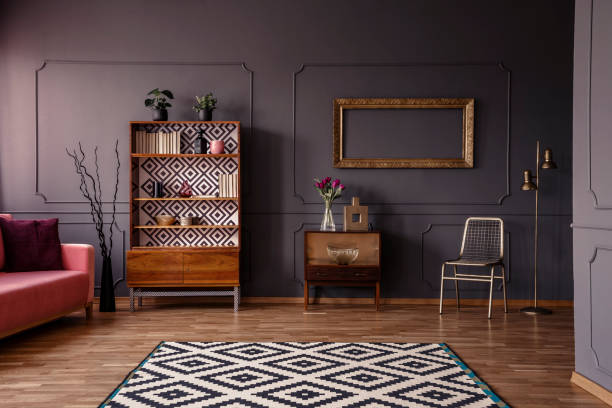 istock Patterned carpet in spacious grey retro living room interior with pink settee and gold chair. Real photo 1018804716