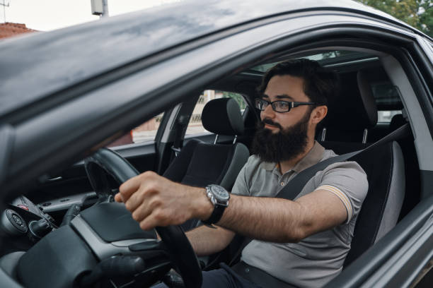 istock Modern casual bearded man driving a car 1018811614