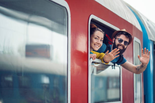 Couple travelers waving from the train window