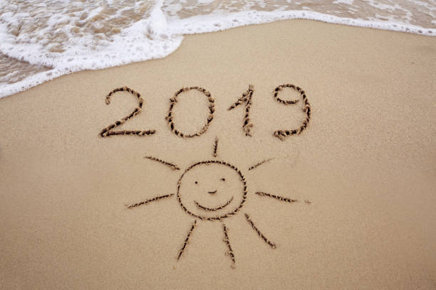 istock Year 2019 written at the caribbean sand beach with sea wave 1018830672