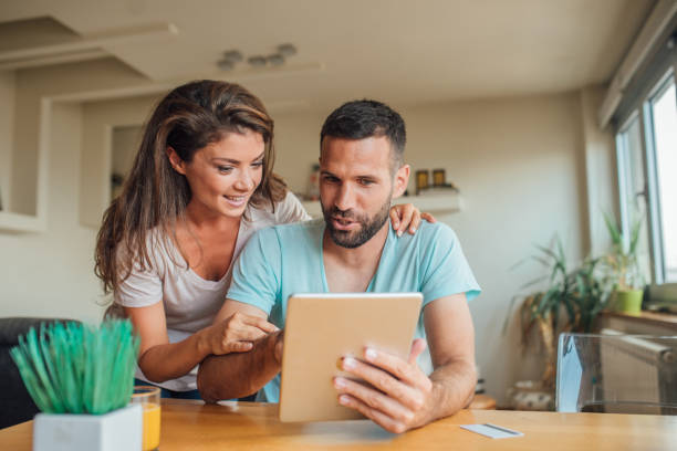 istock Young woman hugging a man with digital tablet in his hands 1018832150