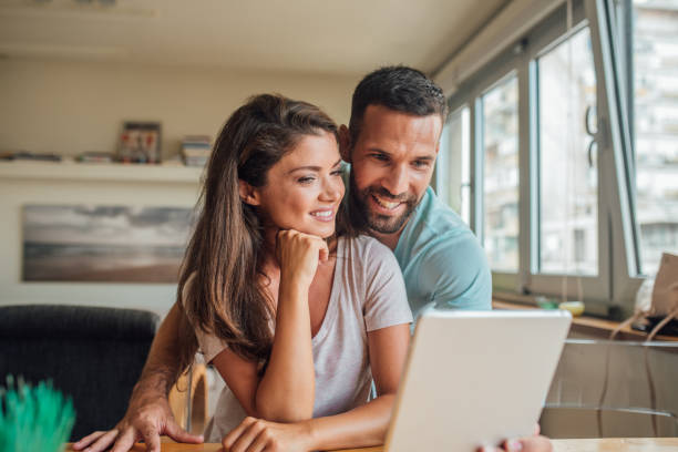 istock Young man hugging girlfriend and taking selfie with digital tablet 1018834478