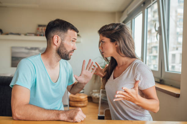 istock Young couple in quarrel, hand gesturing and looking a each other 1018835190