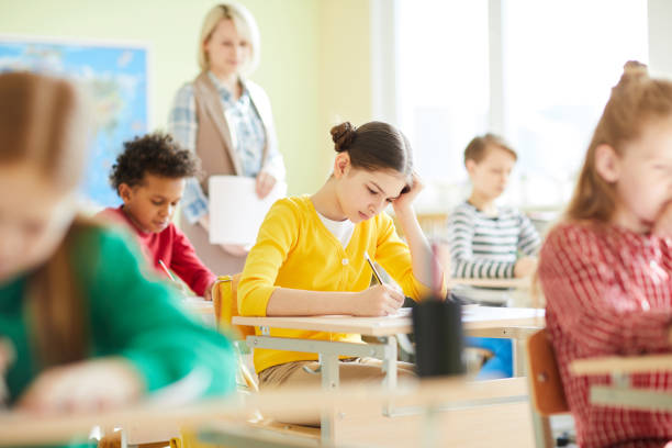 istock Confused schoolgirl having problem with quiz 1018839260