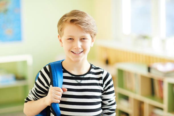 istock Cheerful confident pupil in corridor 1018839424