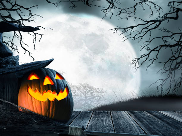 istock Jack O'Lantern Sits On Porch In Front Of Rising Full Moon 1018846060