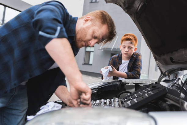 istock father and son repairing car with open hood 1018863380
