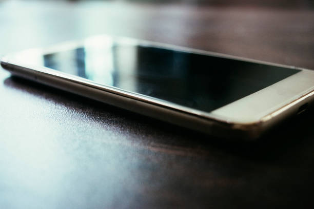 istock smart phone on dark wooden table 1018865250