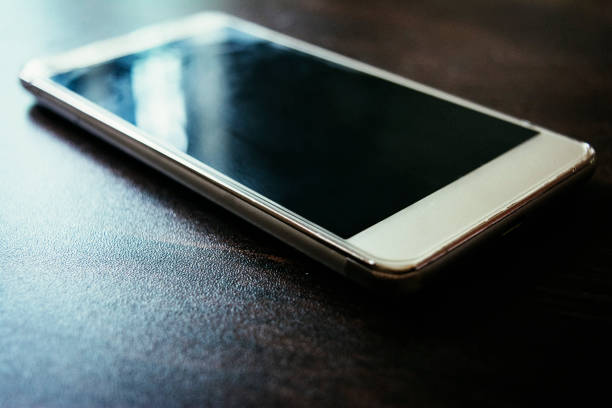 istock smart phone on dark wooden table 1018865266