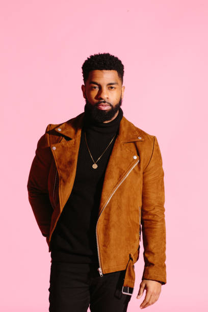 Stylish, handsome and cool African American man with beard, isolated on pink studio background Stylish, handsome and cool African American man with beard, isolated on pink studio background turtleneck photos stock pictures, royalty-free photos & images