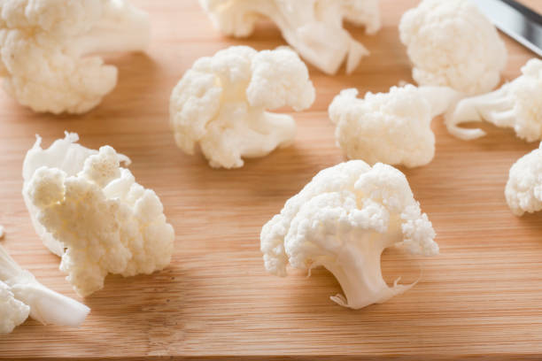 istock Cauliflower fresh organic, cut into small pieces on wooden background. Selective focus 1018873540