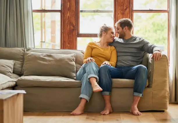 Shot of a young couple being affectionate on the sofa in the living room at home