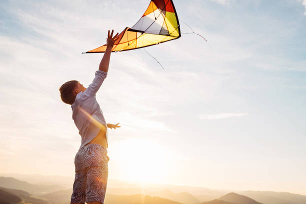 istock Boy jumps and strats to fly a kite in the sky 1018884146