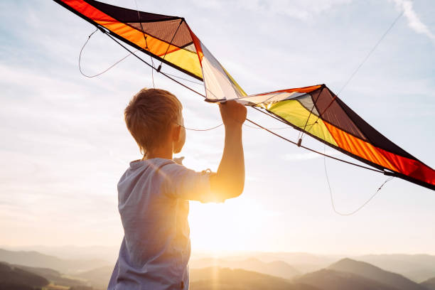 istock Boy prepare to fly a kite over the mountain hills 1018884174
