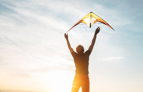 istock Man start to fly a kite in the sky 1018884254