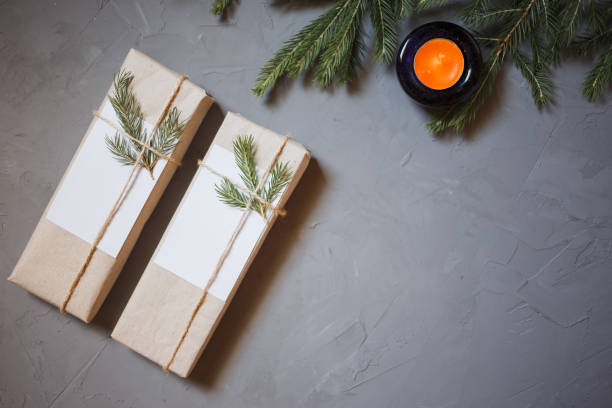 istock Christmas background with fir tree and decor. Top view with copy space, two gift boxes, candle, gray plastered background 1018888642