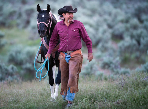 istock Senior cowboy walking alongside his horse 1018889866