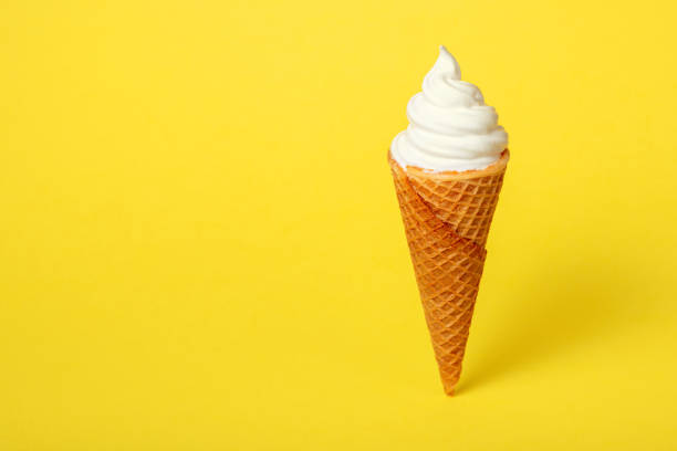 istock soft vanilla ice cream in waffle cone on yellow background, close up, decoration creative concept 1018897526