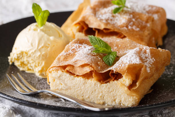 Beautiful strudel with cottage cheese, with vanilla ice cream close-up on a plate. horizontal Beautiful strudel with cottage cheese, with vanilla ice cream close-up on a plate on a table. horizontal strudel stock pictures, royalty-free photos & images