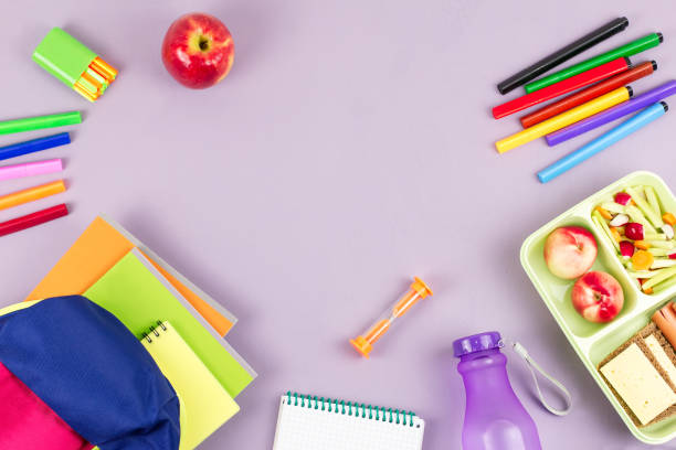 istock School concept flat lay. Kid backpack, lunchbox, water bottle, notebook, markers on wooden desktop 1018901208