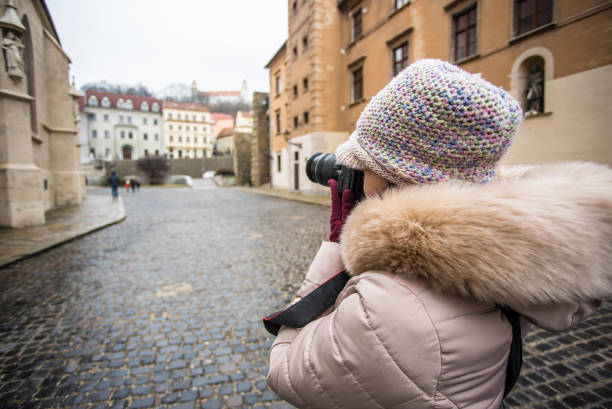 Tourist girl is taking photos in old town of Bratislava, capital of Slovakia.