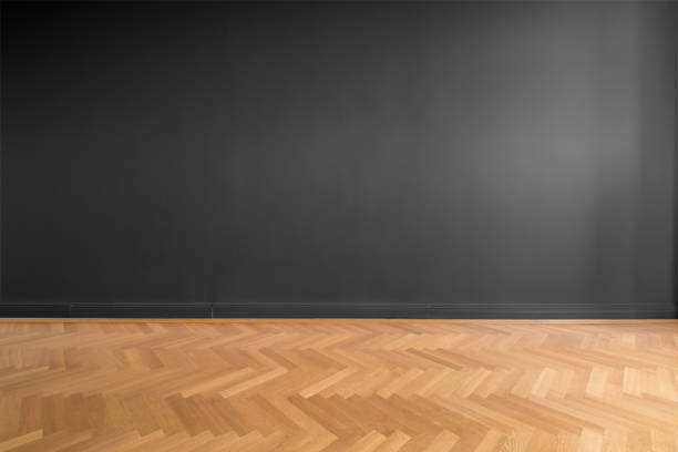 istock empty room with black wall background and wooden parquet floor 1018922006