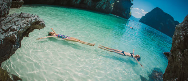 istock Two friends lying on water surface in crystal clear sea 1018922246