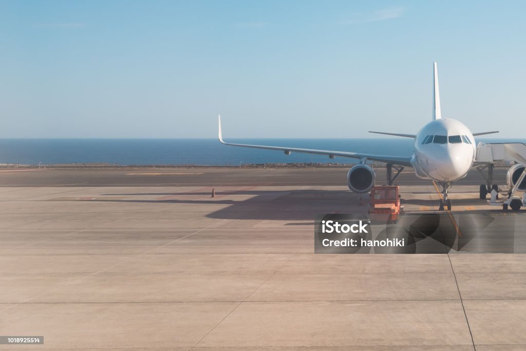 parte delantera del pie del avión en la pista con el fondo del océano - Foto de stock de Avión libre de derechos
