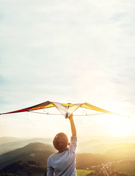 In dreams about flying. Boy takes a kite over his head In dreams about flying. Boy takes a kite over his head kite toy stock pictures, royalty-free photos & images