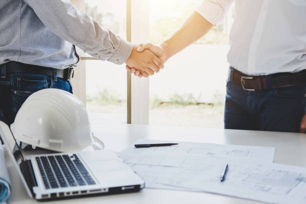 Two engineer or architect meeting for project, handshake after consultation and conference new project plan, contract for both companies, success, partnership stock photo