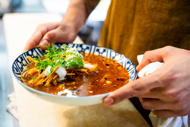 mexican chef serving aztec soup in an authentic mexican restaurant - mexican dish imagens e fotografias de stock