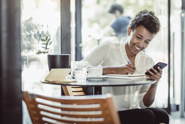 istock Young Businesswoman at a cafeteria taking notes 1018943182