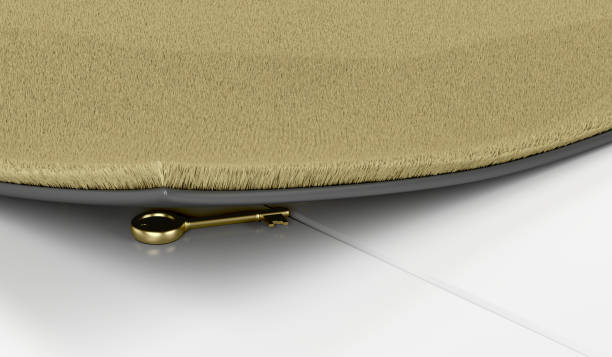 Golden key under the doormat Golden key hidden under the doormat, close up key doormat stock pictures, royalty-free photos & images