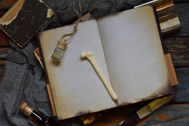 istock Things hunter for evil, demons, vampires and zombies - an old notebook, a book with spells, a knife, flask of holy water, pen bone, alcohol, a cross. Men's accessories on a dark background. 1018963066