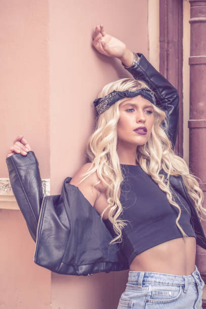 istock Girl in a  jacket  posing near brown wall 1018965996