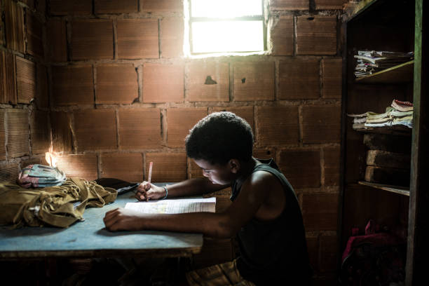 ragazzo brasiliano che studia a casa - slum living foto e immagini stock