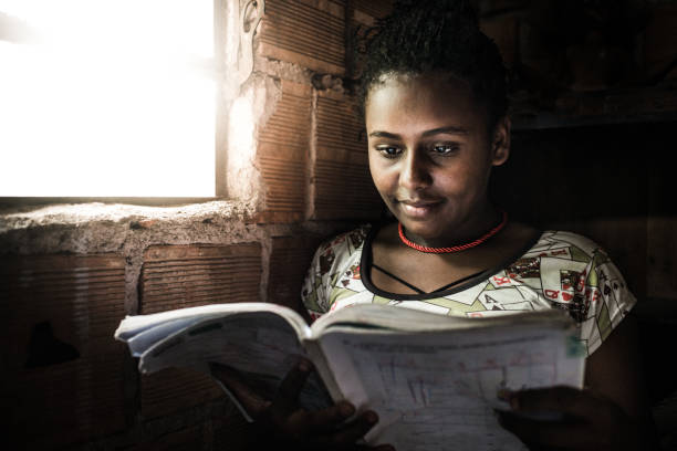 ragazza brasiliana che studia a casa - slum living foto e immagini stock