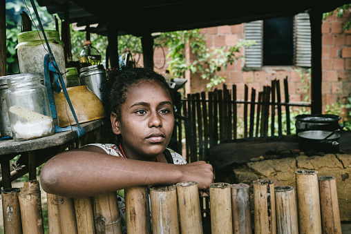 Brazilian girl at her home in the kitchen of a wood stove. Rio de Janeiro State, Brazil.