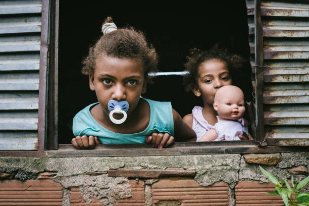 бразильские дети у окна - slum living фотографии стоковые фото и изображения
