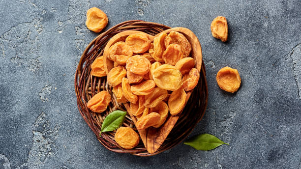 istock Dried apricots on gray concrete background with copy space. Top view. 1018969970