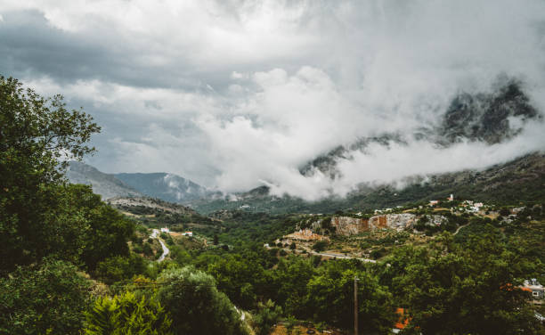 View on mountain with low hanging clouds and green trees. South Crete neat Rethymno, Greece. Photo taken in Greece.